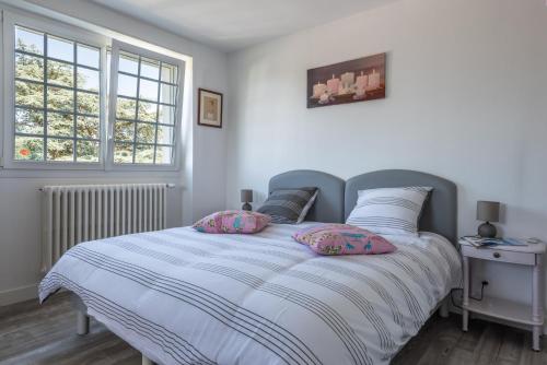 sypialnia z łóżkiem z poduszkami w obiekcie Villa des Fleurs d'Ajoncs w mieście Concarneau