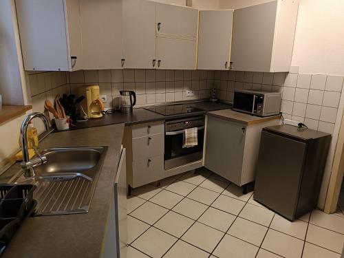 een keuken met een gootsteen, een fornuis en een koelkast bij Ferienwohnung-Haus in Saarbrücken in Saarbrücken