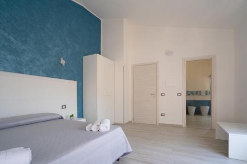 a bedroom with a bed and a blue wall at Harmonia Home Capitello in Capitello