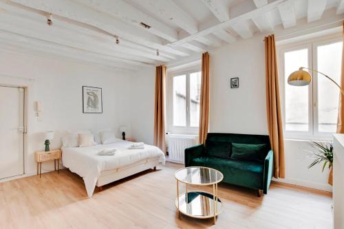 - un salon avec un lit et un canapé vert dans l'établissement Saint placide cannette, à Paris