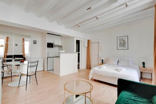 une chambre blanche avec un lit et une cuisine dans l'établissement Saint placide cannette, à Paris