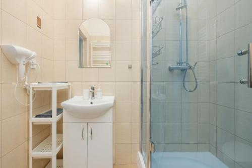 een badkamer met een douche, een wastafel en een toilet bij Apartament Mewa in Dziwnówek
