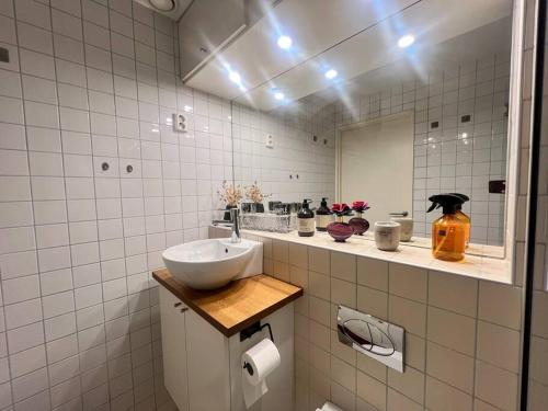 a bathroom with a sink and a mirror at Koselig leilighet i sentrum av OSLO med byutsikt! in Oslo