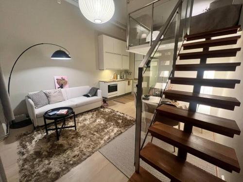 a living room with a white couch and a staircase at Koselig leilighet i sentrum av OSLO med byutsikt! in Oslo