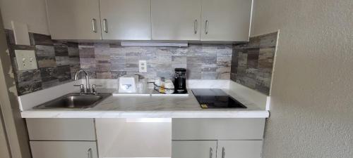 a kitchen with white cabinets and a sink at Days Inn by Wyndham Conway in Conway