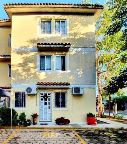 a yellow house with a white door and windows at ESTUDIO EL ANGEL. in Santa Cruz Huatulco