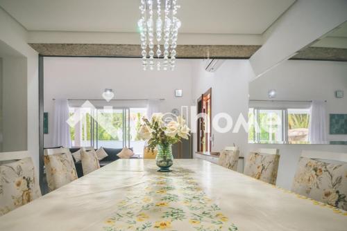 une salle à manger avec une grande table et des chaises dans l'établissement Casa com piscina a 10 minutos da praia em Bertioga, à Riviera de São Lourenço