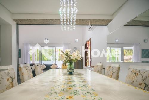 a dining room with a long table and chairs at Casa com piscina a 10 minutos da praia em Bertioga in Riviera de São Lourenço