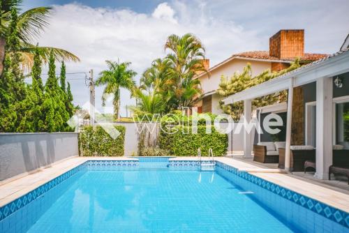 a swimming pool in the backyard of a villa at Casa com piscina a 10 minutos da praia em Bertioga in Riviera de São Lourenço