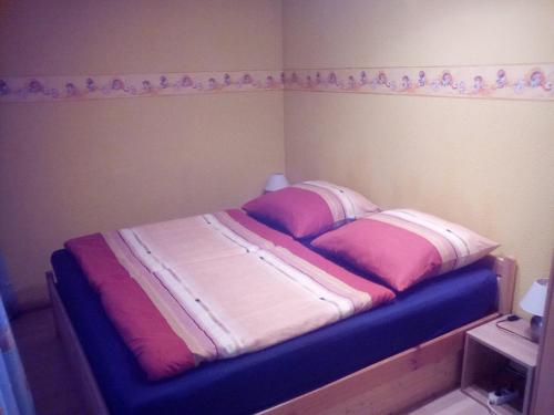 1 dormitorio con 1 cama con sábanas rosas y blancas en Ferienwohnung Eulitz, en Peickwitz