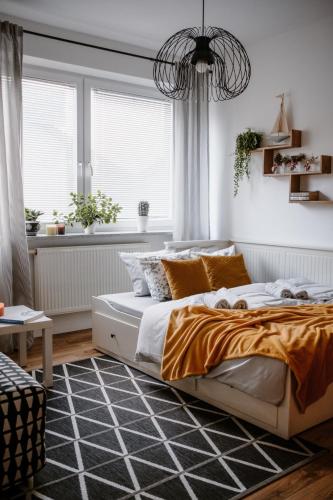 a bedroom with a bed and a large window at Apartament White in Giżycko