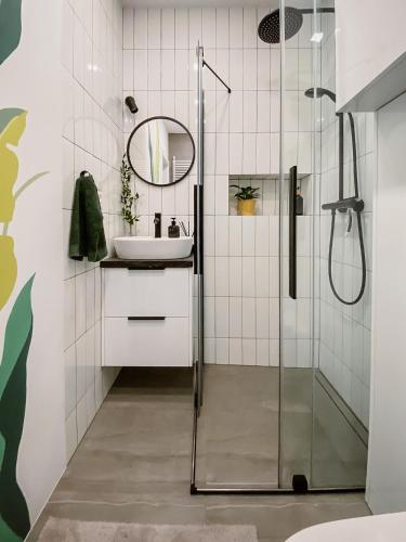 a bathroom with a sink and a shower at Apartament White in Giżycko