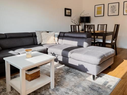 a living room with a couch and a table at Apartament White in Giżycko