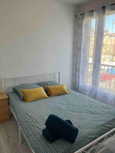 - une chambre dotée d'un grand lit avec des oreillers jaunes et bleus dans l'établissement Grand Appartement le Saint Marceaux Reims centre, à Reims