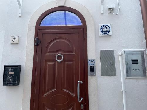 a brown door in a white building with a window at G&M Home in Castellana Grotte
