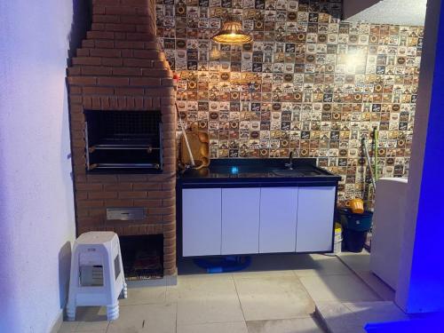 a kitchen with a brick wall and a counter top at Casa pertinho da praia doTombo in Guarujá