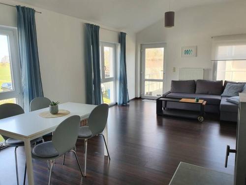 a living room with a couch and a table and chairs at Ferienwohnung MaLaMaBu am Kitespot Saal Ostsee in Saal