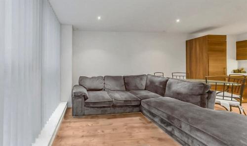 a leather couch in a living room with a table at 1 Bedroom Apartment in City Centre in Belfast