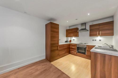 a kitchen with wooden cabinets and a counter top at 1 Bedroom Apartment in City Centre in Belfast