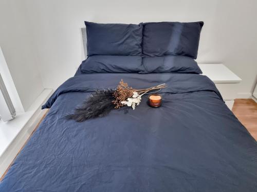 a bed with blue sheets and a candle on it at 1 Bedroom Apartment in City Centre in Belfast