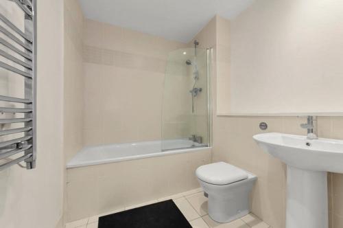a white bathroom with a toilet and a sink at 1 Bedroom Apartment in City Centre in Belfast