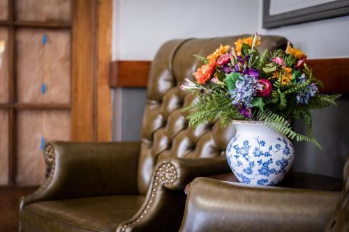 a blue and white vase with a bouquet of flowers on a chair at Gardner Hotel & Hostel in El Paso