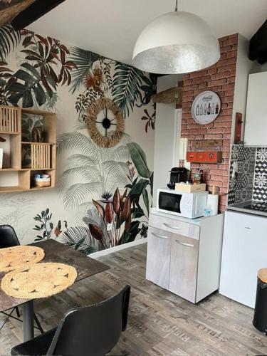 - une cuisine avec une table et un four micro-ondes dans l'établissement LE BALI, à Besançon