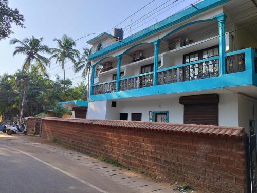 a building with a blue balcony and a brick wall at Casa De Rocks in Calangute