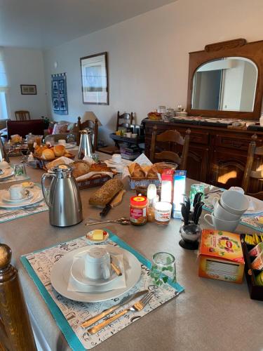 B&B l'Aigrin في دربي: طاولة مطبخ مع طاولة عليها طعام
