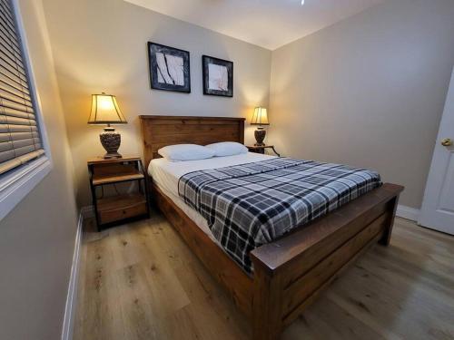 a bedroom with a bed with two night stands and two lamps at Firefly Hut - Cheerful 6-bedroom cottage with serene beauty in McDougall