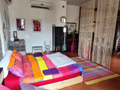 - une chambre avec un lit et une couverture colorée dans l'établissement La casa della mamma, à Gubbio