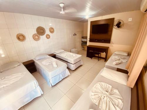 a hospital room with three beds and a television at Pousada Jovimar in Aparecida
