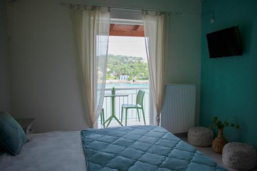 a bedroom with a bed and a window with a table at VILLA ATHINA in Paleokastritsa