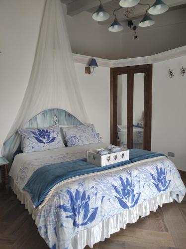 a bedroom with a bed with a blue and white bedspread at Caledonia B&B in Mercato San Severino