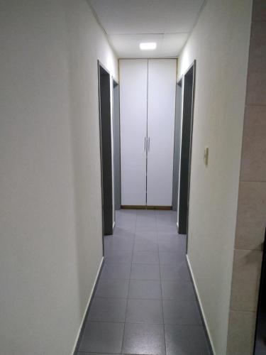 un couloir aux murs blancs et aux portes blanches dans l'établissement Alojamiento laura, à Puerto Santa Cruz