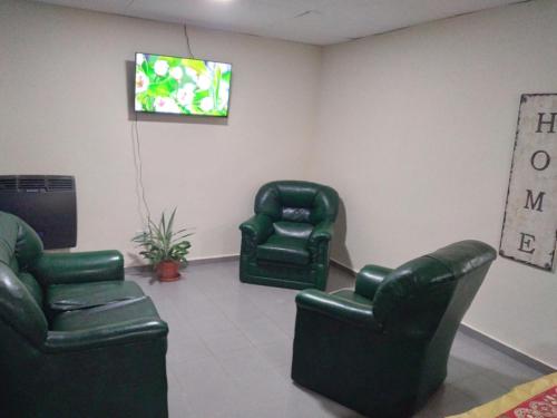 a waiting room with two chairs and a tv at Alojamiento laura in Puerto Santa Cruz