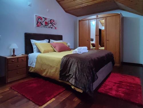 a bedroom with a bed with a dresser and a mirror at Casa das Camélias in Viseu