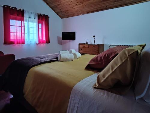 a bedroom with two large beds with red windows at Casa das Camélias in Viseu