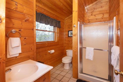 y baño con ducha, aseo y lavamanos. en Peaceful Haven en Sevierville