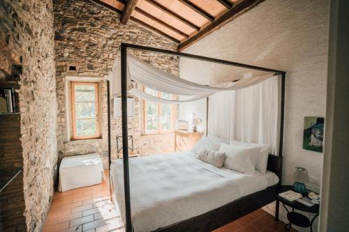 a bedroom with a canopy bed in a brick wall at Agriturismo Le Valli in Casciana Terme