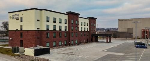 a large brick building in a parking lot at Cobblestone Hotel & Suites - Ottumwa in Ottumwa