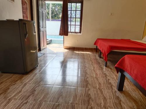a room with two beds and a red blanket on the floor at Casa De Rocks in Calangute