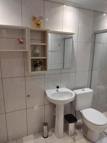 biała łazienka z toaletą i umywalką w obiekcie Apto Dom Victor 101 w mieście Gramado