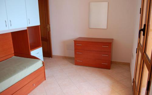 een slaapkamer met een bed en een houten dressoir bij Rifinito appartamento con veranda vista mare a Maladroxia C65 in Maladroscia