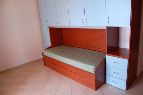 un piccolo letto in una stanza con armadi bianchi di Rifinito appartamento con veranda vista mare a Maladroxia C65 a Maladroscia