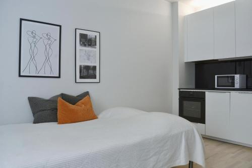 Habitación blanca con cama y microondas en Modern and Bright Studio with Top Location, en Helsinki