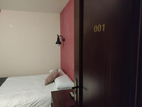 een kleine slaapkamer met een bed en een roze muur bij Hotel Cabo Ortegal in Cariño