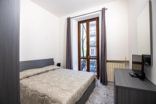 1 dormitorio con 1 cama, TV y ventana en Casa Malu', en Legnano
