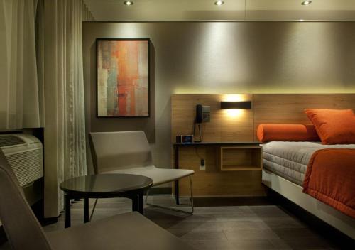 um quarto com uma cama, uma mesa e uma cadeira em Motel Idéal Ste-Rose em Laval