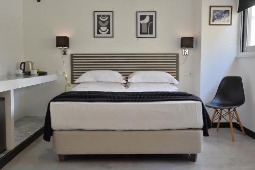 1 dormitorio con 1 cama grande y 1 silla negra en Alter Athens en Atenas